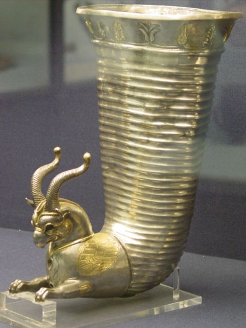 a gold vase with an animal figurine in it