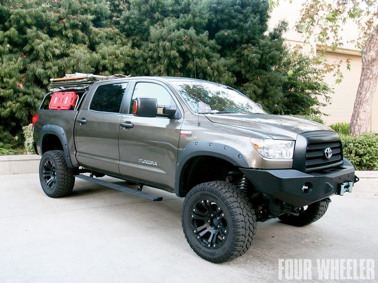 a gray truck parked in front of some trees