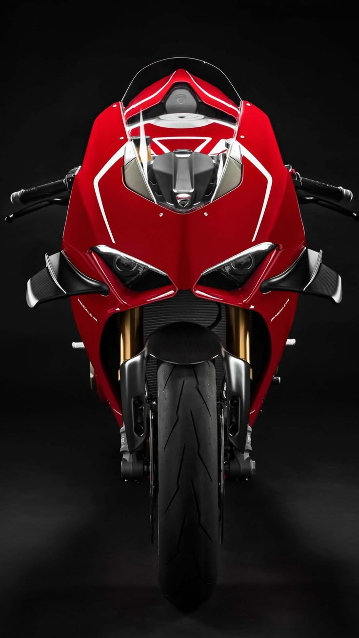 the front end of a red motorcycle on a black background