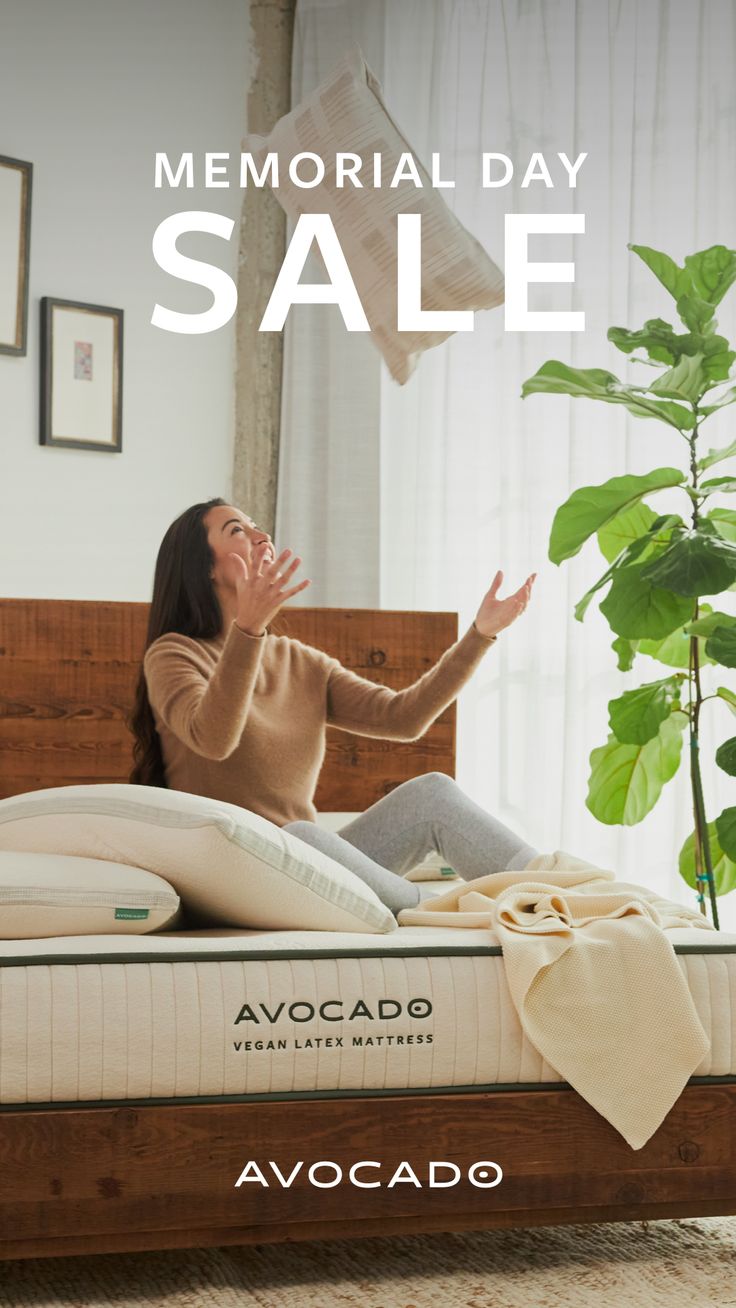 a woman sitting on top of a bed in front of a window with the words memorial day sale written above it