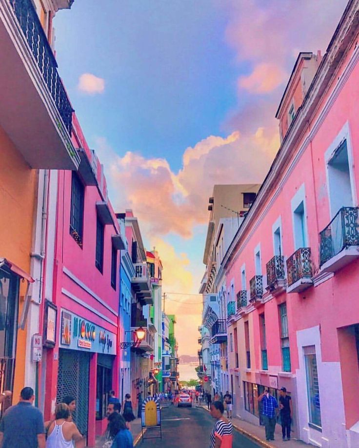 people walking down the street in front of colorful buildings