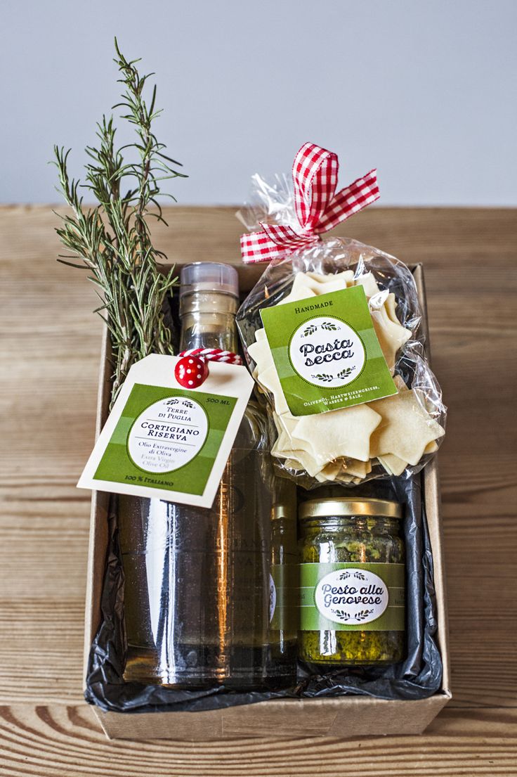 an open gift box filled with olives, cheese and other food items on a wooden table