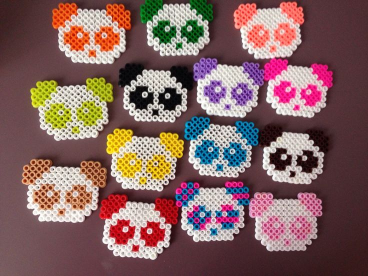 cross stitch panda bear coasters are arranged on a purple surface, each with different colors