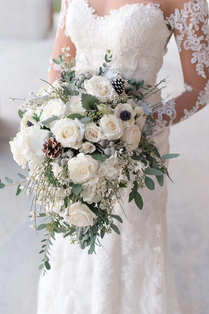 a bride holding a bouquet of white flowers