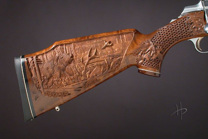 a wooden knife with carvings on the handle and sides is shown in close up view