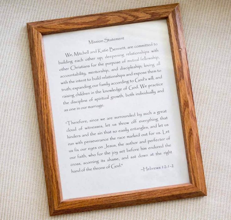 a wooden frame with a poem written in it on a white cloth covered tablecloth