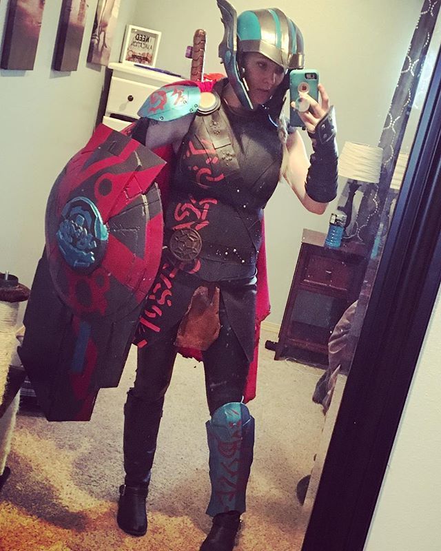 a woman dressed in armor taking a selfie