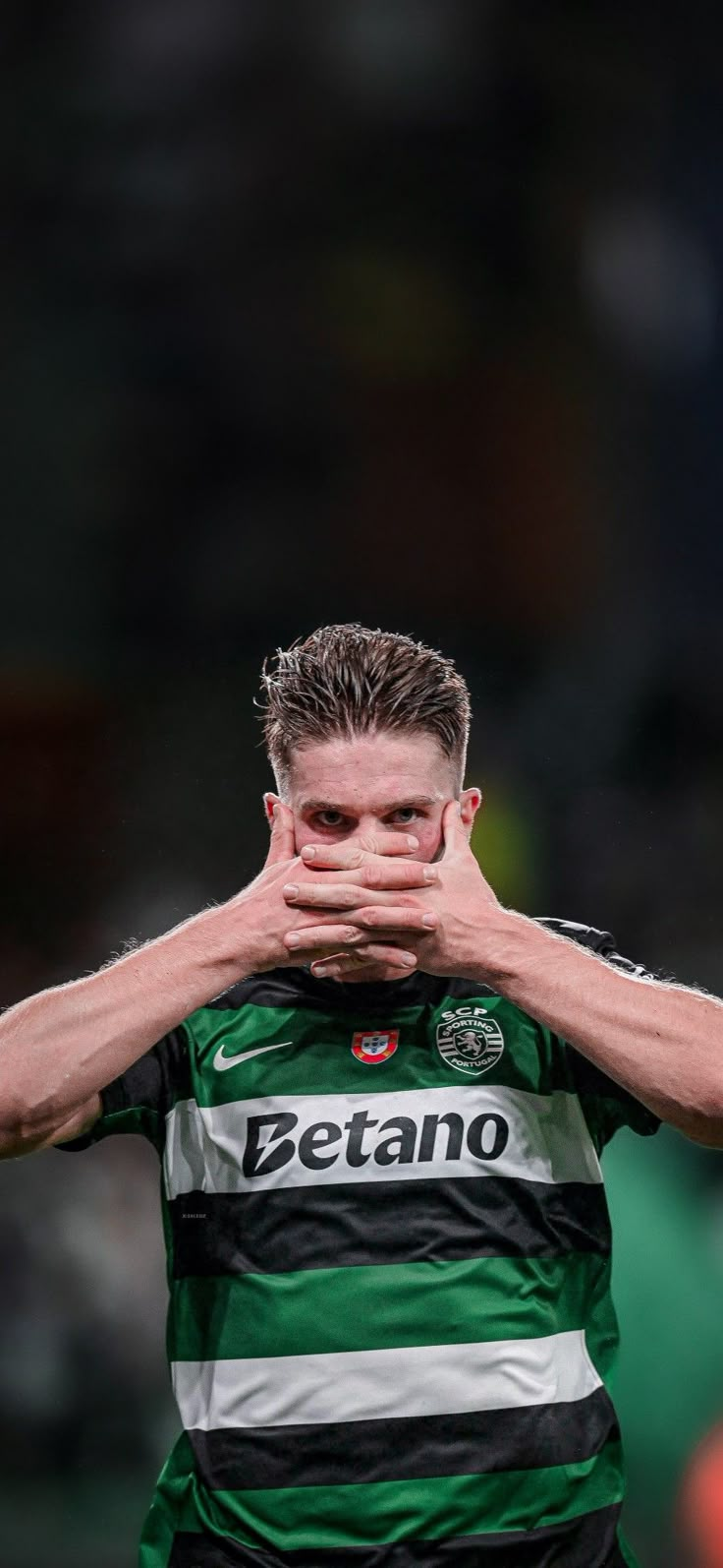 a soccer player is covering his face with his hands