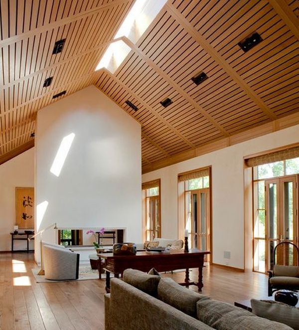 a large open living room with wood flooring and vaulted ceiling, along with two couches