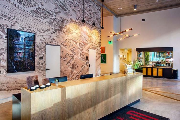 an office lobby with a large map on the wall and wooden reception desk in front of it