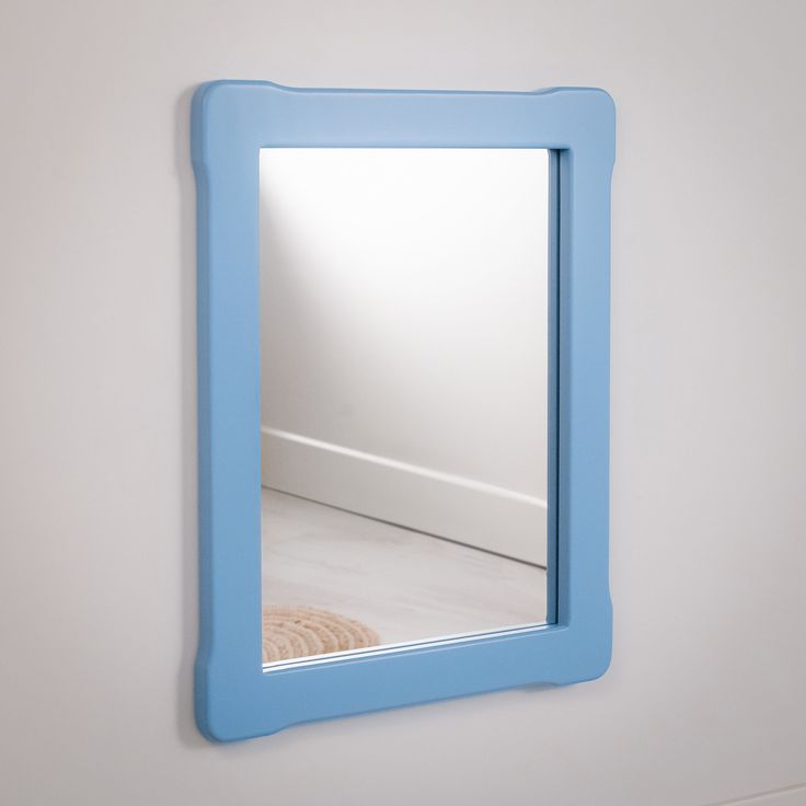 there is a mirror on the wall with a blue frame around it and a white floor