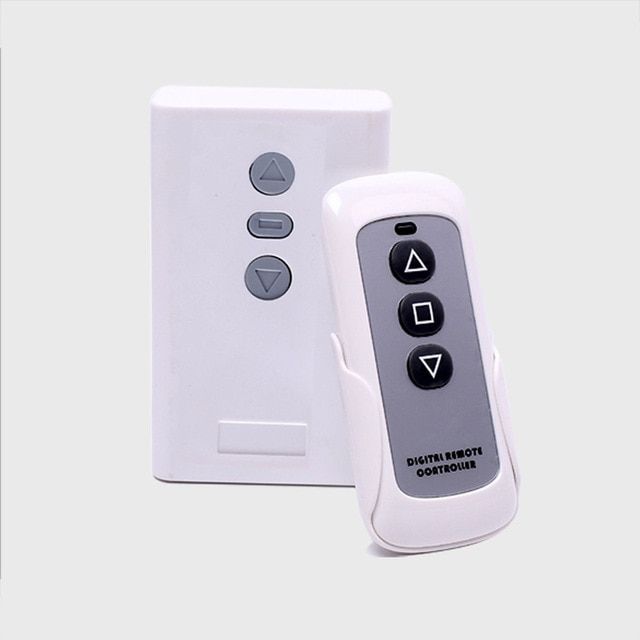 a remote control sitting next to a white wall mounted light switch box on a gray background