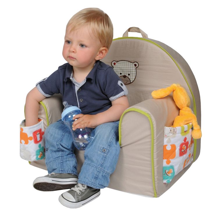 a little boy sitting in a chair with stuffed animals on the seat and holding a water bottle