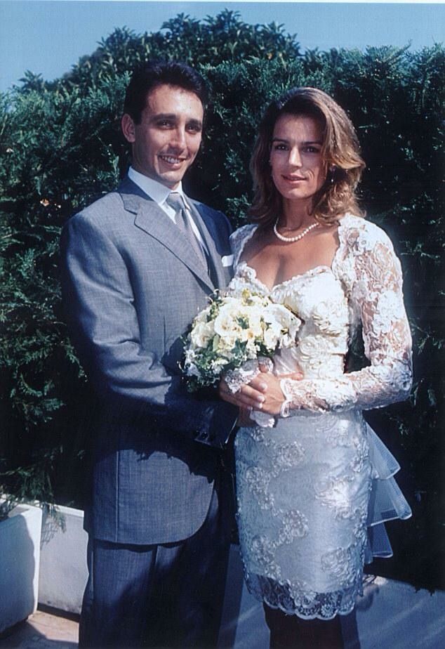 a man in a suit and woman in a wedding dress posing for a photo together