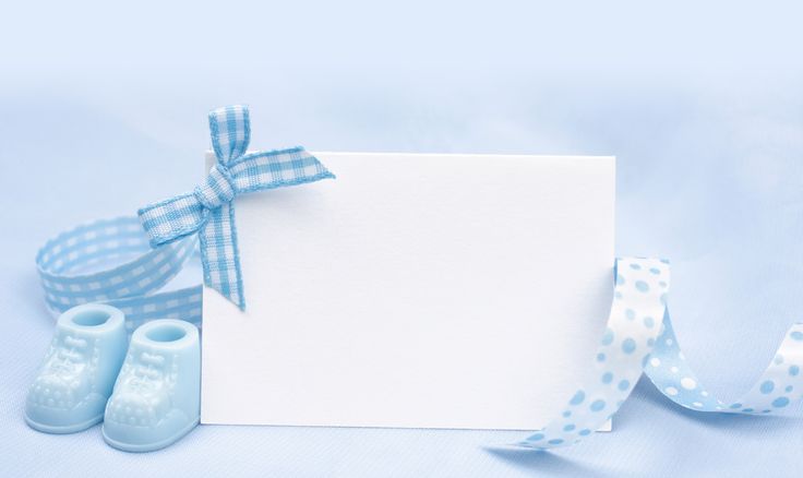 blue baby booties are next to a white card with a polka dot ribbon on it