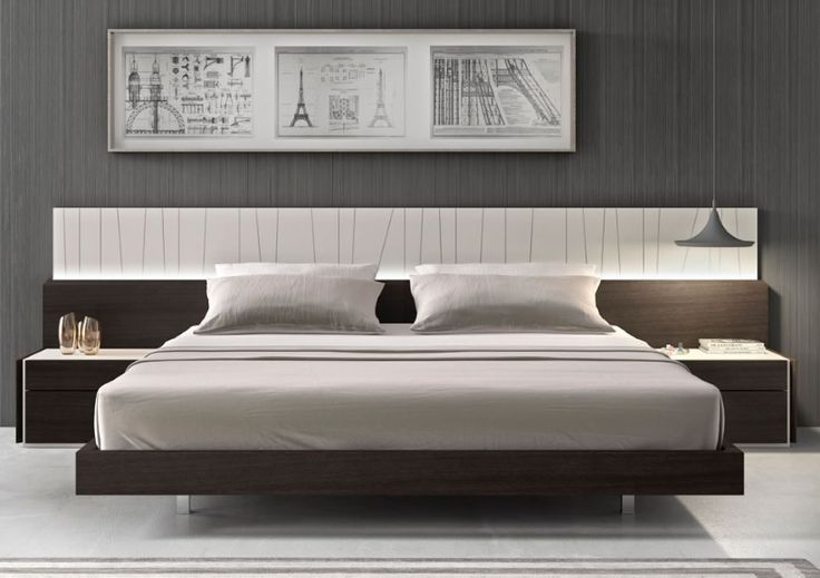 a bedroom with a bed, nightstands and pictures on the wall above it in grey tones