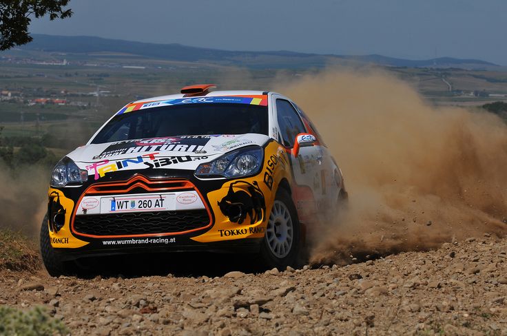 a rally car driving down a dirt road