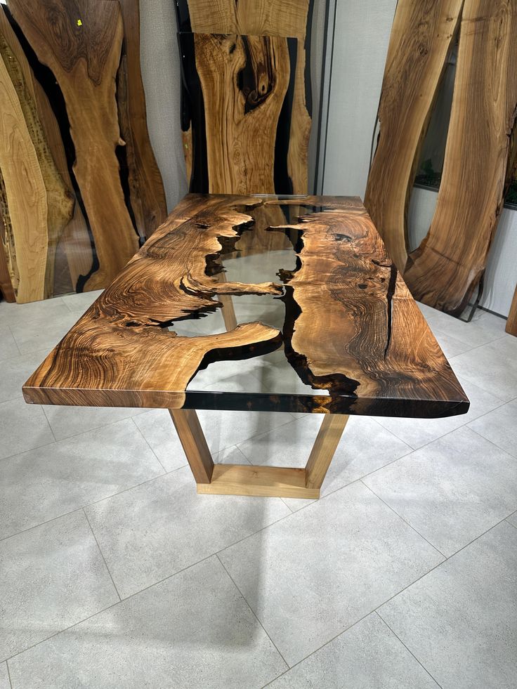 a table made out of wood and glass in a room with wooden chairs behind it