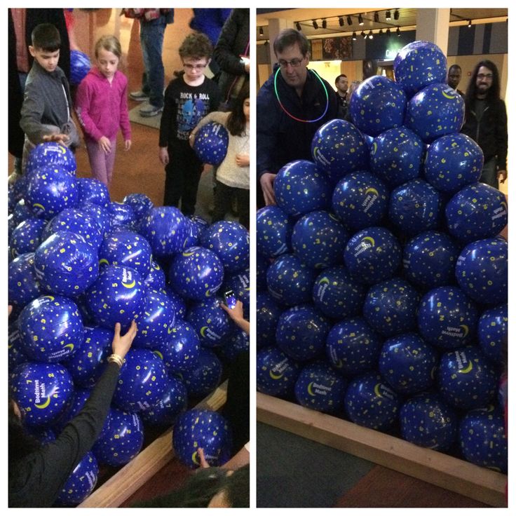 there are many blue balloons in the store and one is being held up by someone's hand