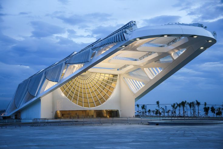 a large white building with stairs leading up to it's roof and sky in the background