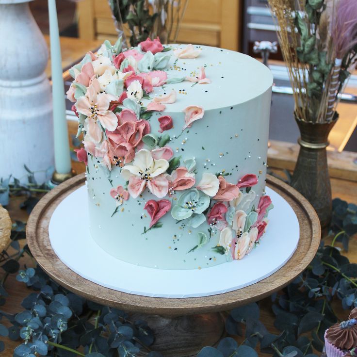 there is a blue cake with pink flowers on it