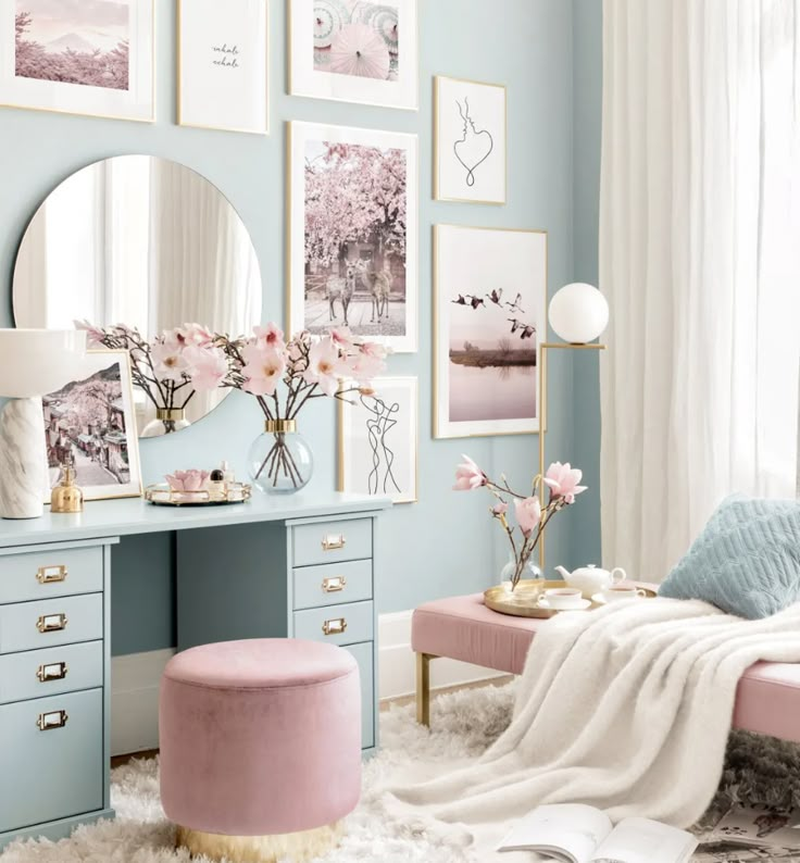 a bedroom decorated in pastel blue and pink with pictures on the wall above it