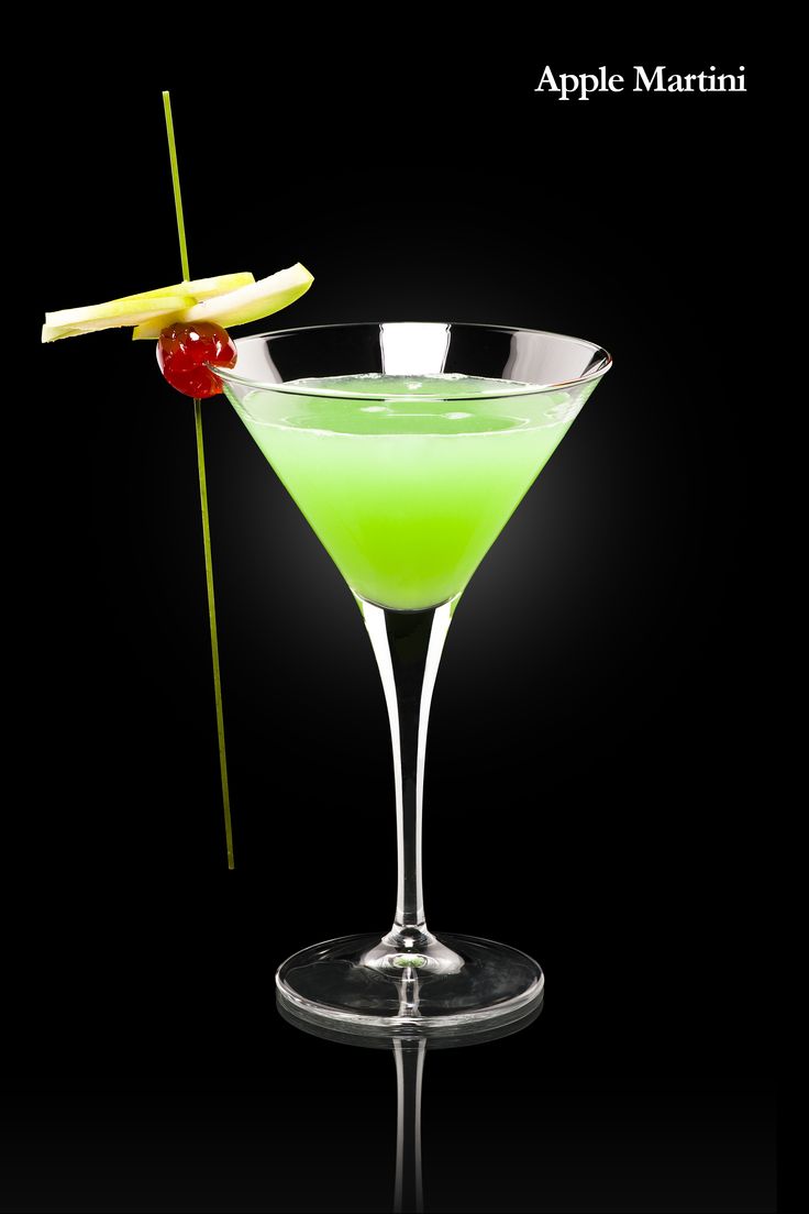 an apple martini with a cherry garnish on the rim and a pickle