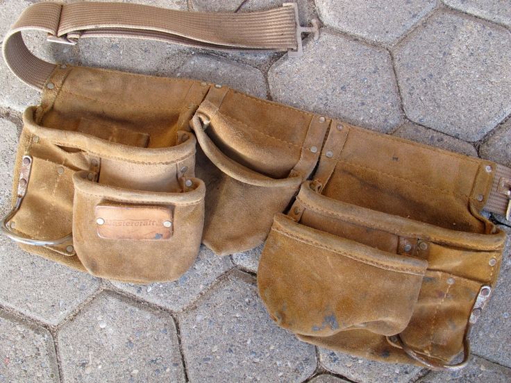 three brown leather bags sitting on top of a stone floor next to a bag strap