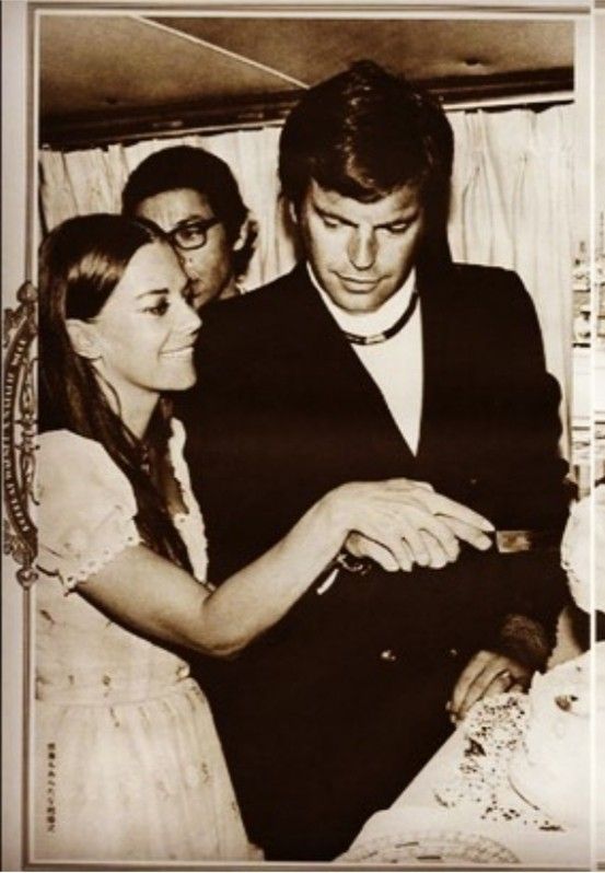 an old black and white photo of a couple cutting their wedding cake