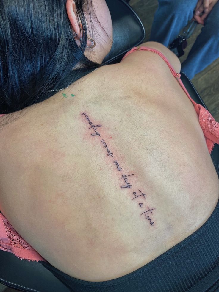 the back of a woman's body with writing on her lower back and upper back