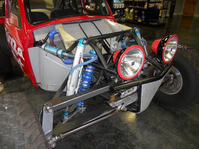 an off road vehicle is parked in a garage with its lights on and the front bumper up