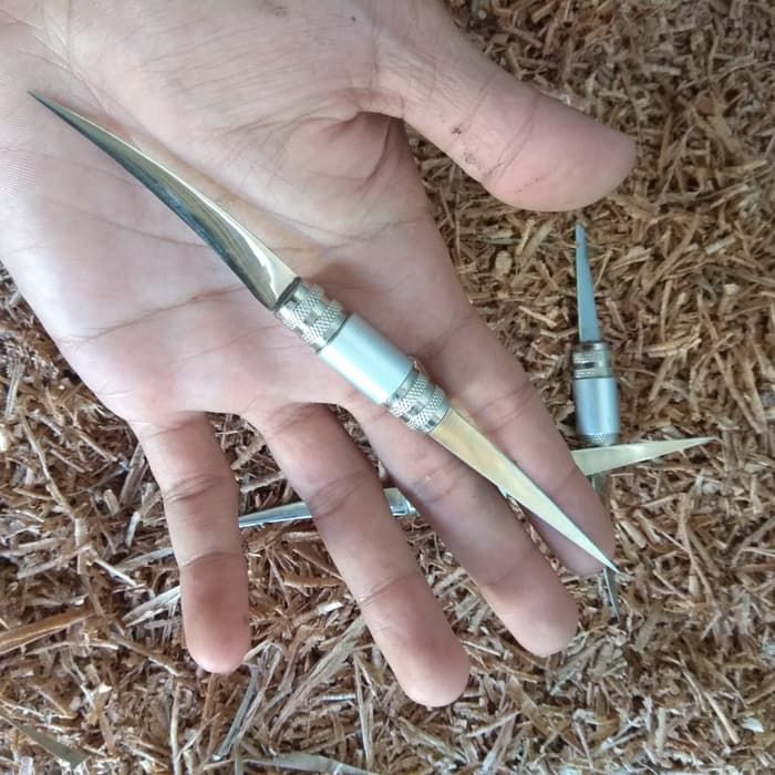 a person's hand with two small scissors in it