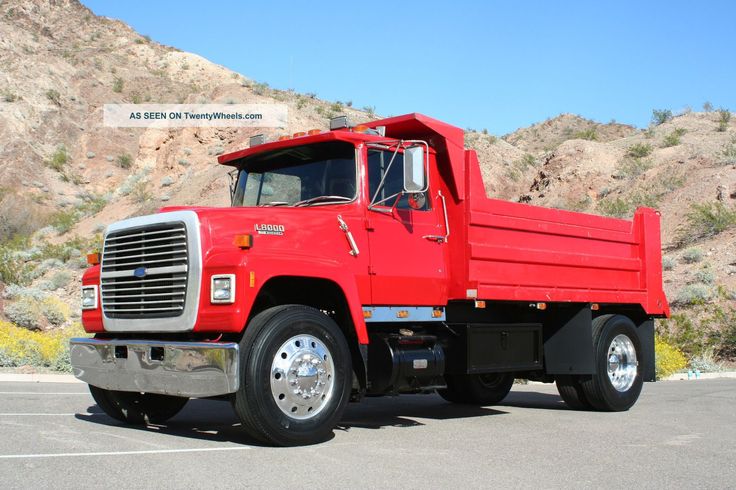 a red dump truck parked in a parking lot