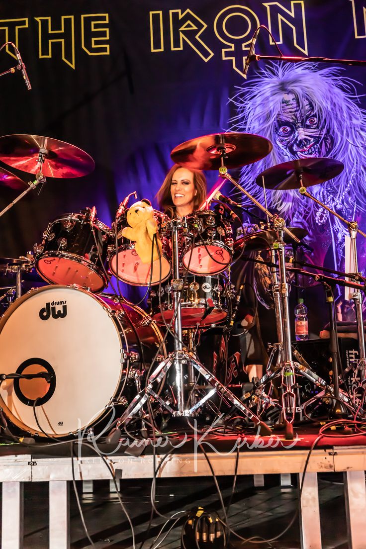 the iron maiden band performing on stage with their drums in front of an image of a lion