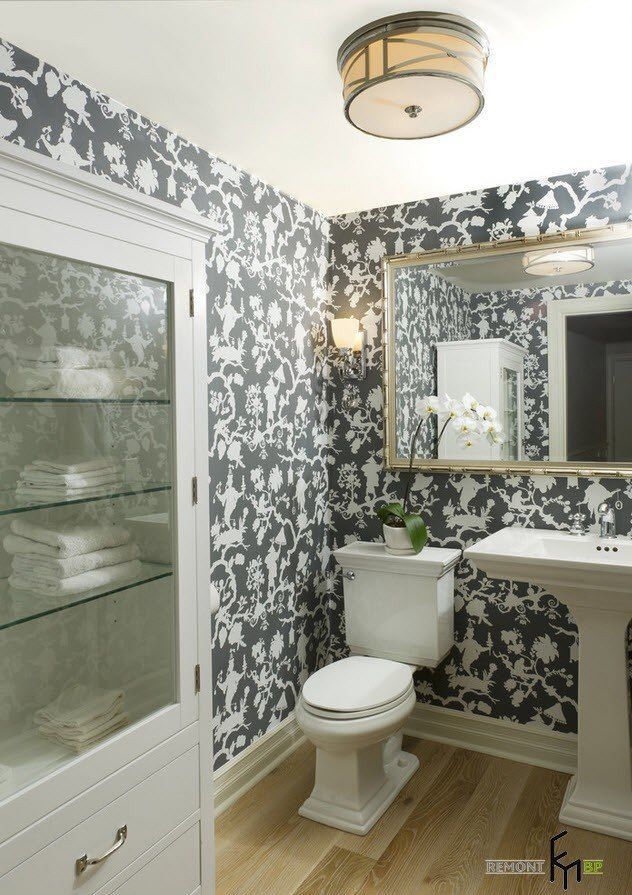 a white toilet sitting under a bathroom mirror next to a sink and a counter top