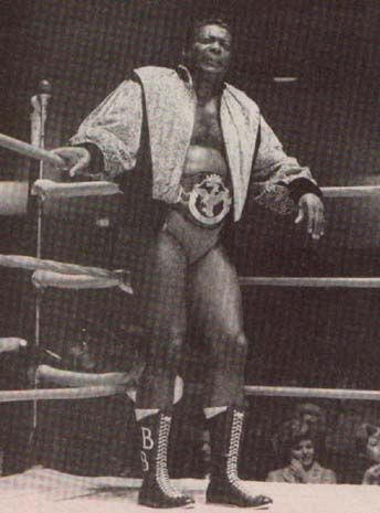 an old photo of a man standing next to a boxing ring