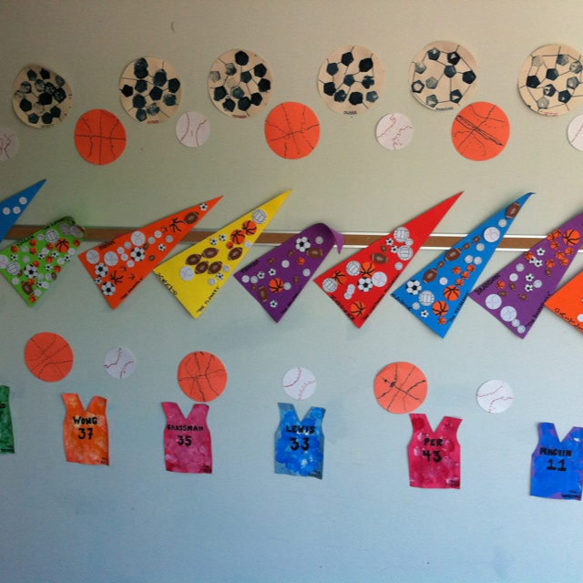 a bulletin board with sports themed items on it and numbers pinned to the wall above them