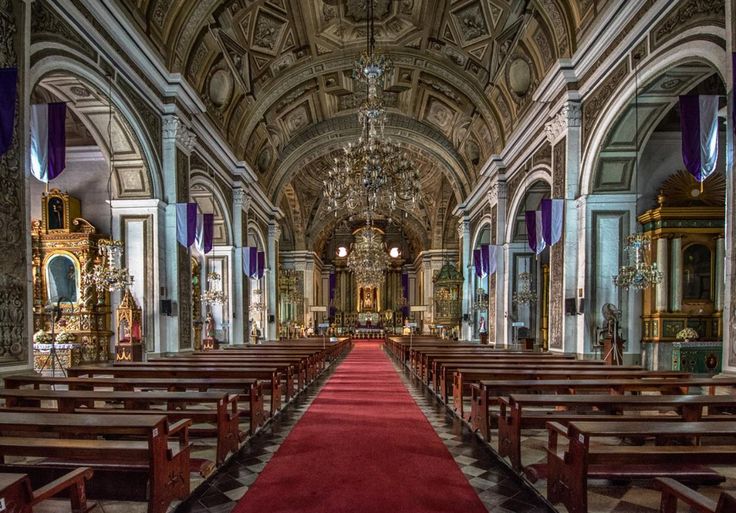 an empty church with pews and chandeliers