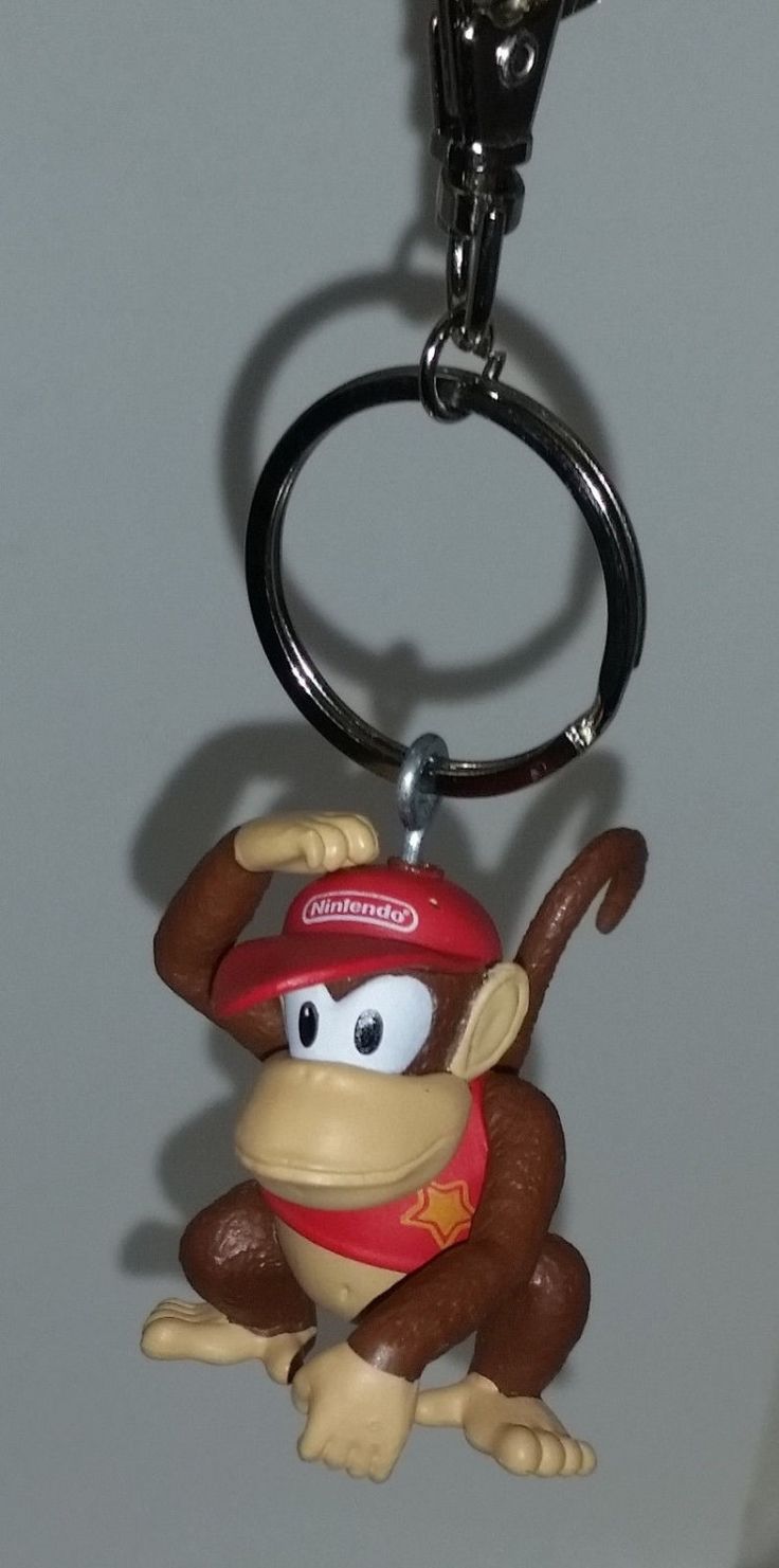 a monkey keychain with a baseball cap on it's head