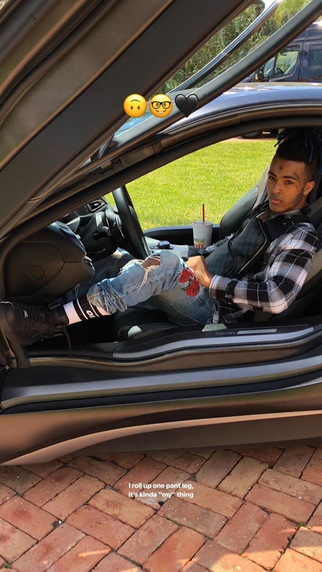 a man sitting in the driver's seat of a car with his feet up