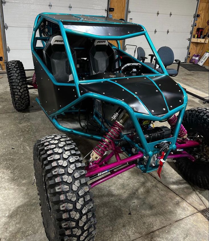 a pink and blue buggy parked in a garage