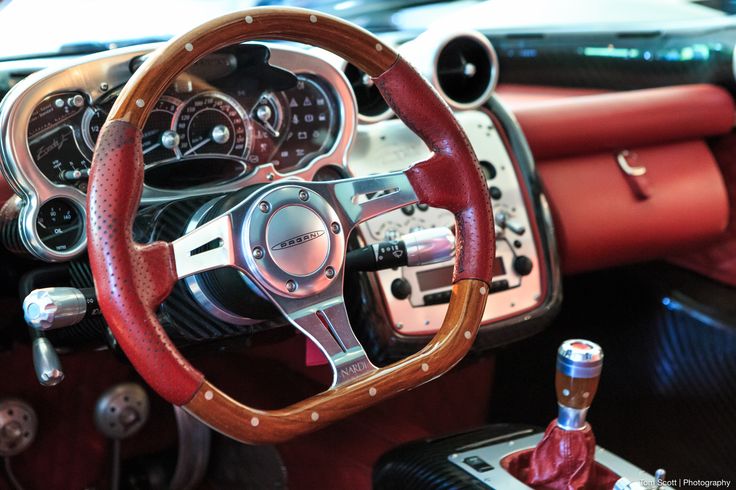 the interior of a car with red leather steering wheel covers and gauges on it