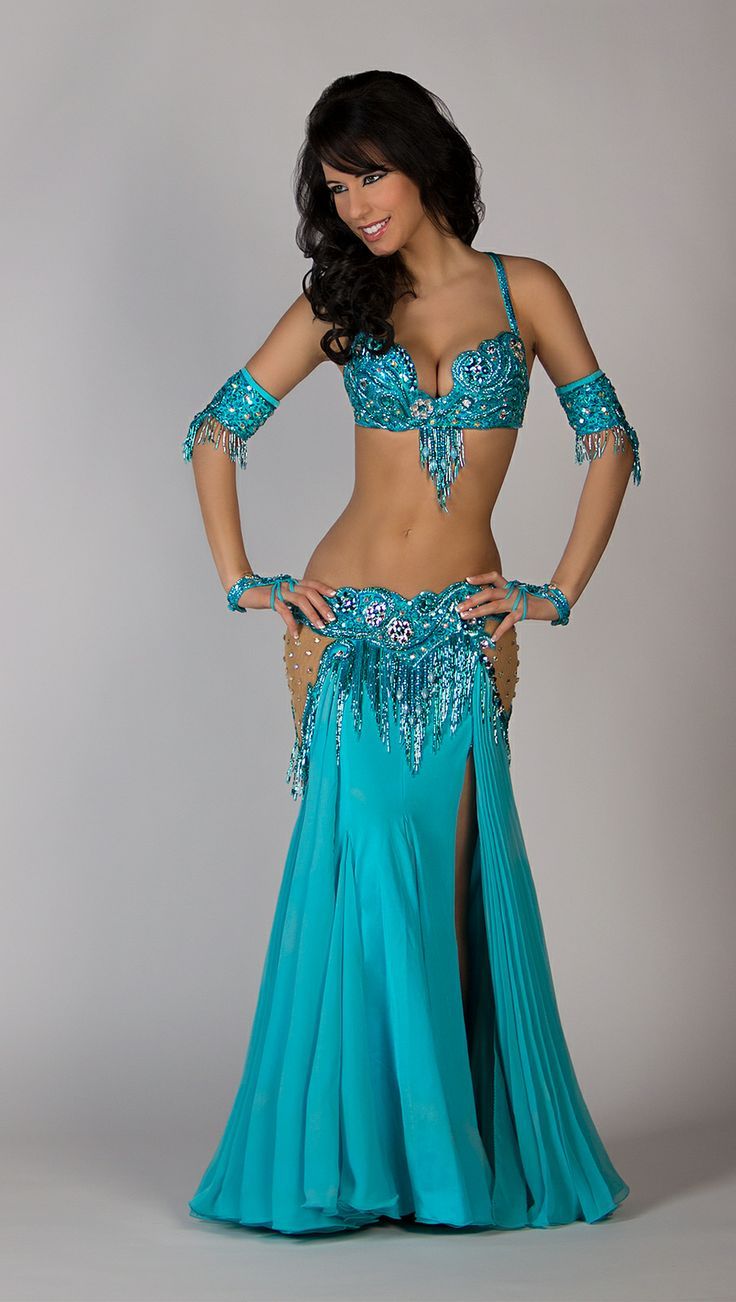 a woman in a blue belly dance outfit posing for a photo with her hands on her hips