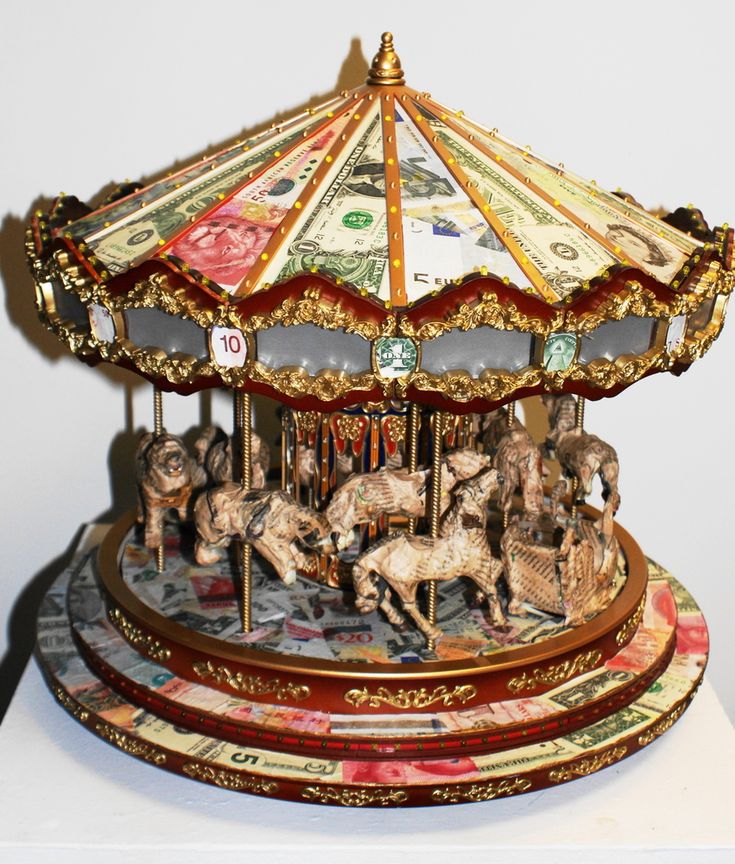 a carousel with horses on it sitting on top of a white tableclothed surface