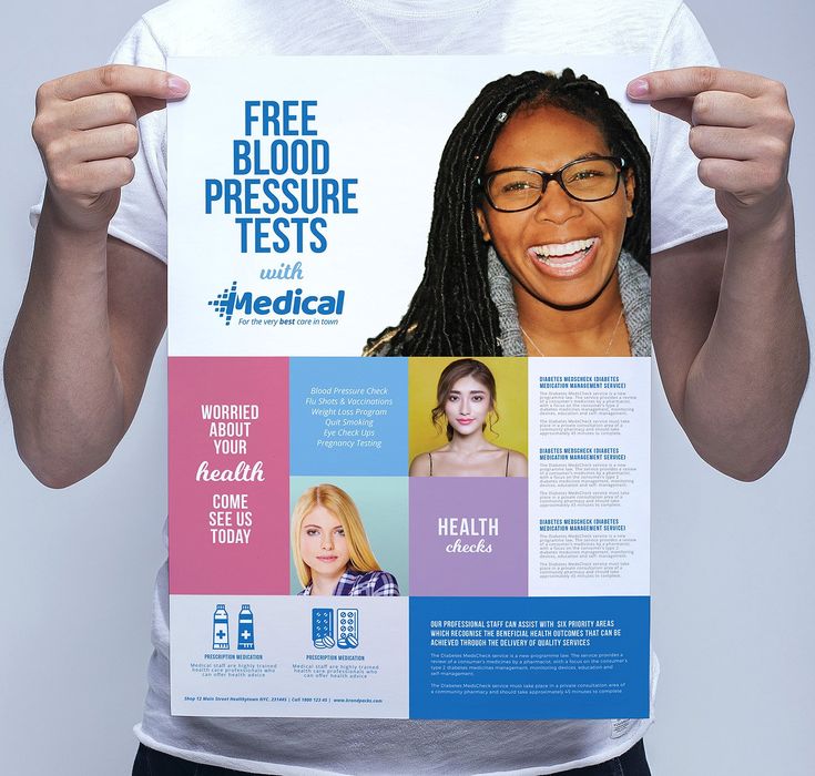 a person holding up a poster with the words free blood pressure tests and medical on it