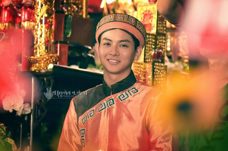 a young man wearing an orange and black outfit standing in front of a store display