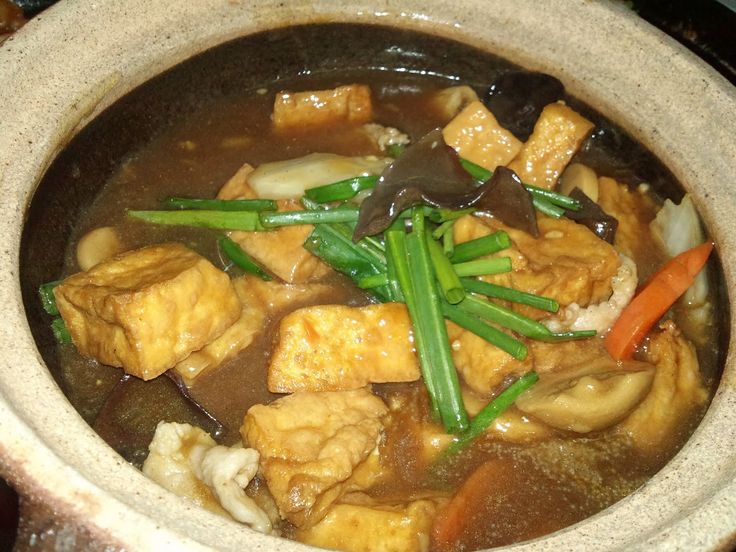 a bowl filled with meat and vegetables on top of a table