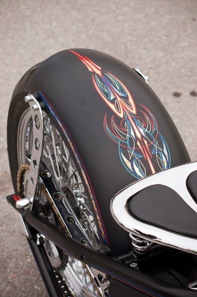 the front end of a motorcycle with an artistic design on it's seat cover