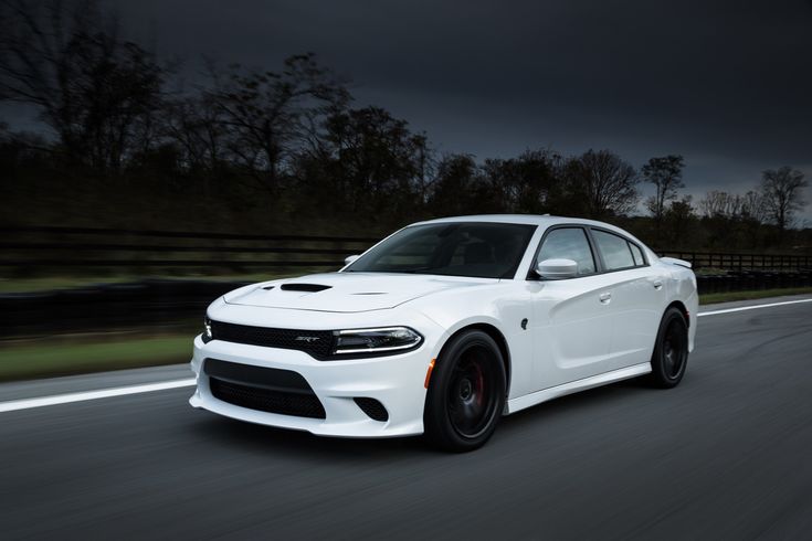 a white dodge charger driving down the road