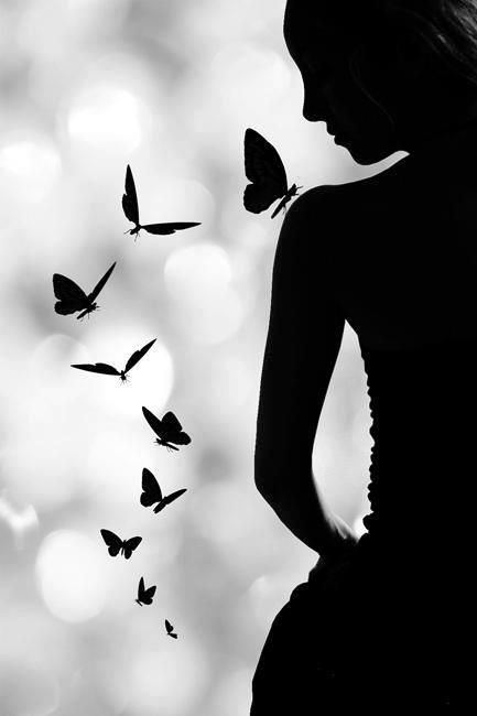 a woman standing in front of a group of butterflies